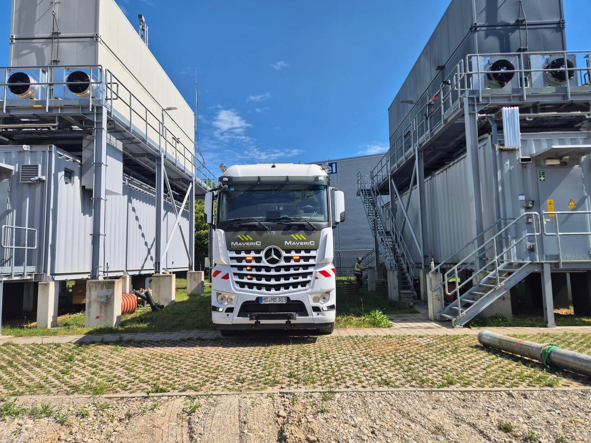 A Maveric vacuum-excavation truck positioned between large items of plant on a data-centre enabling-works site.