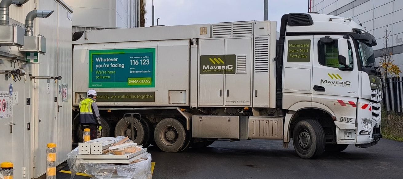 A Maveric vacuum-excavation truck on a live site, with an operative working at the rear suction gear.
