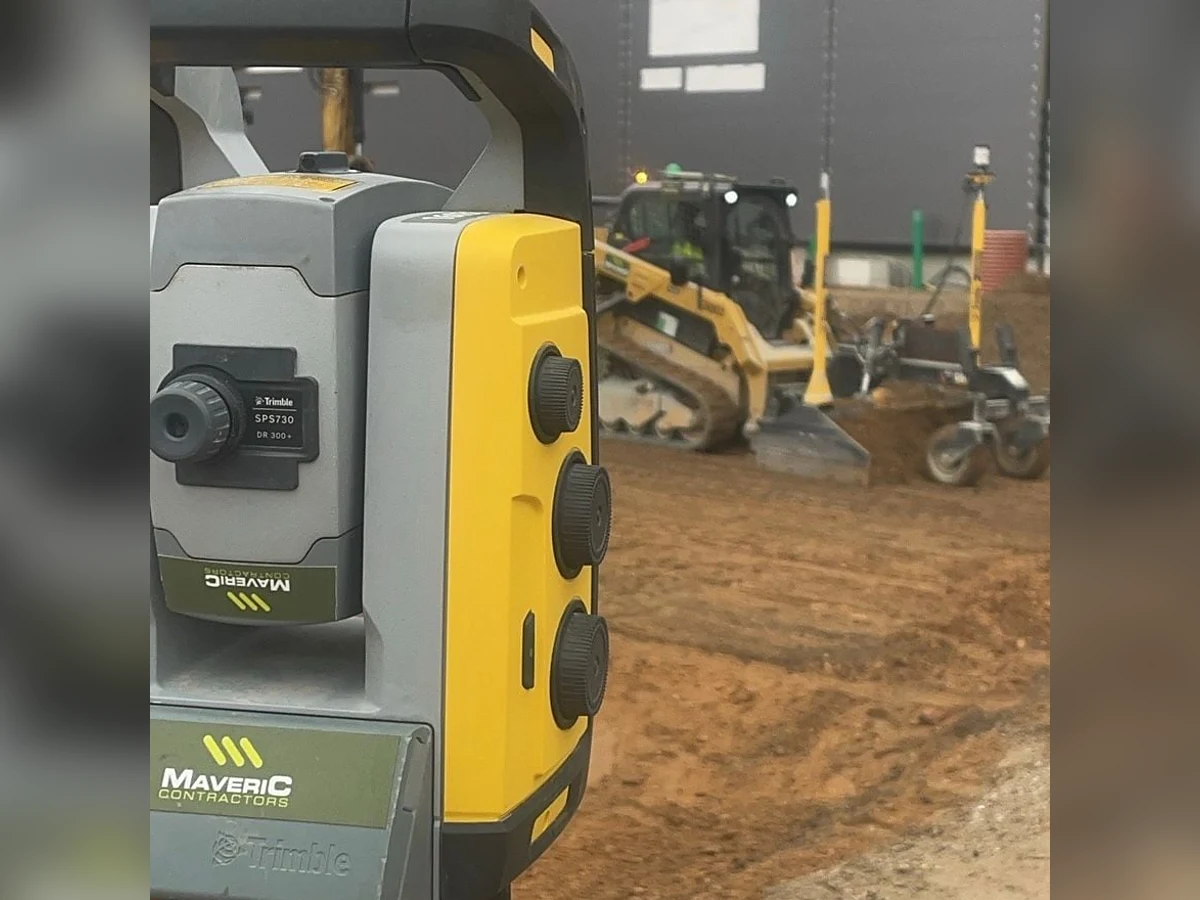 Maveric-branded Trimble SPS730 total station set up beside tracked plant on an active earthworks platform.